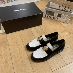CHANEL Black and White Patent Leather Loafers with Gold Lion Ornament image 1