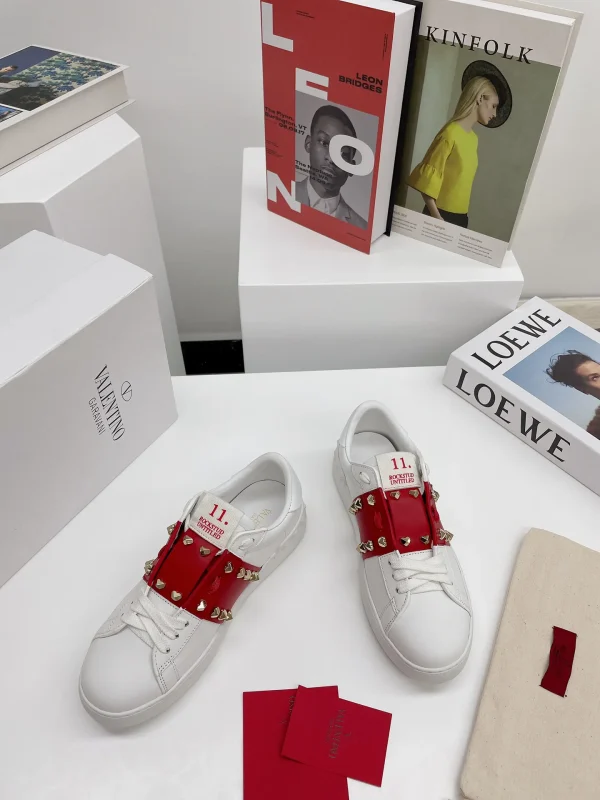 White Low-Top Sneakers with Red Strap and Stud Details image 1